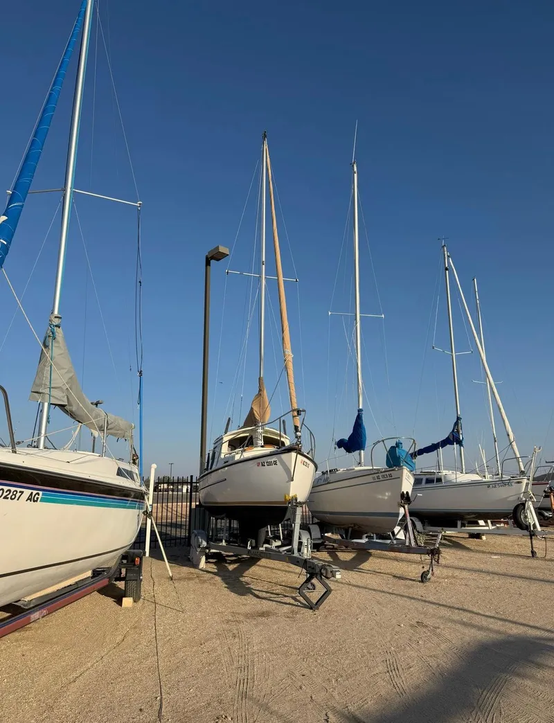 Slide: The Image of 2022 Com-Pac CP 23 Pilothouse sailboat on trailer, surrounded by other boats, under clear blue sky. - 9