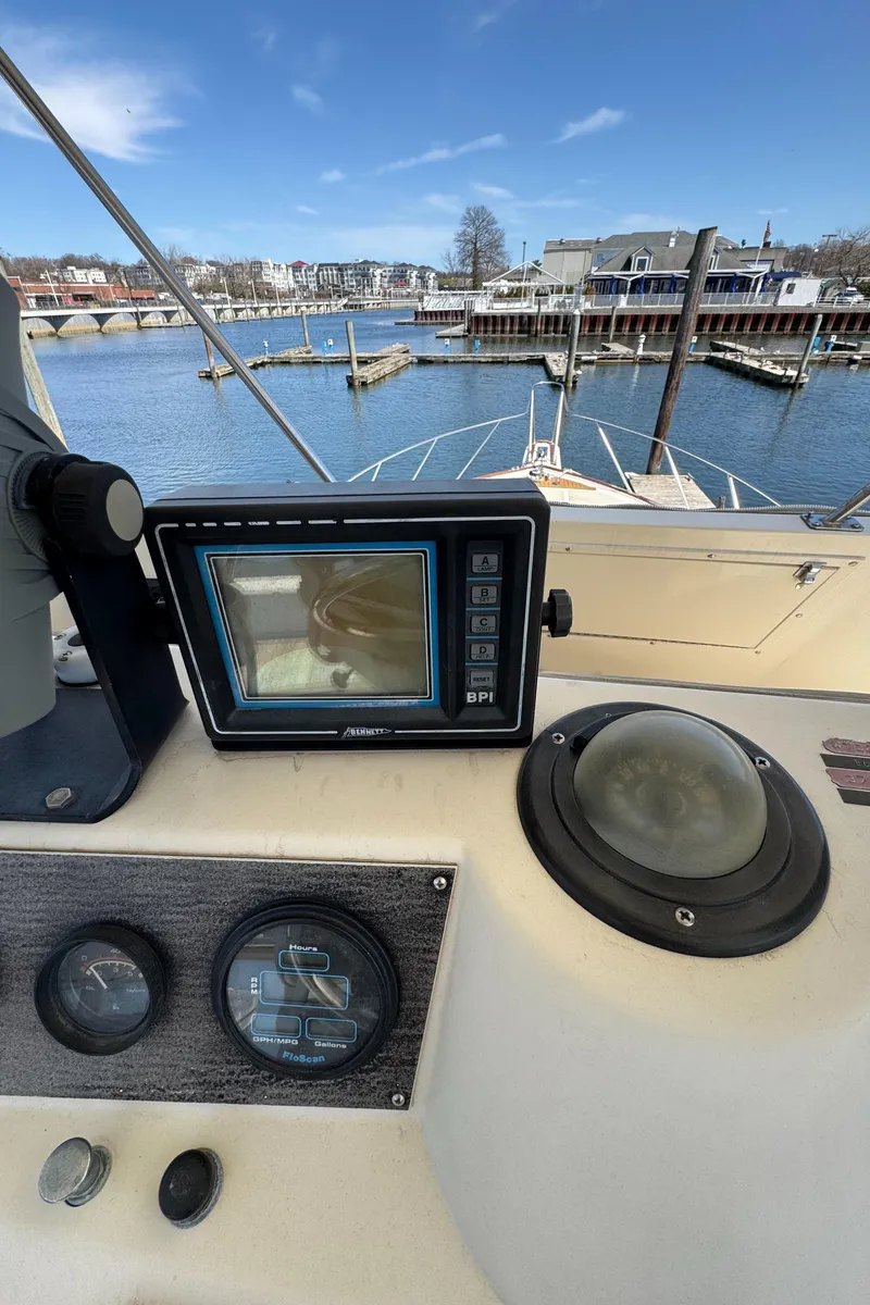 Slide: The Image of 1985 Egg Harbor Convertible boat dashboard with navigation equipment, docked in a marina. - 13