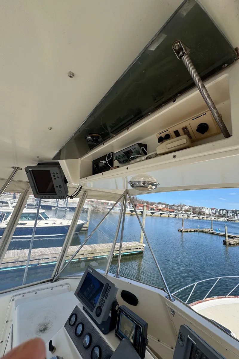 Slide: The Image of 1985 Egg Harbor Convertible boat cockpit with navigation equipment, overlooking marina. - 15