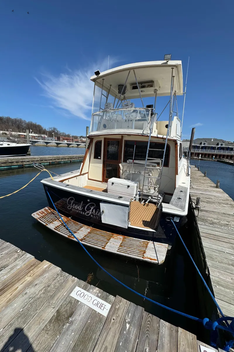 Slide: The Image of 1985 Egg Harbor Convertible boat docked at a marina under a clear blue sky. - 3