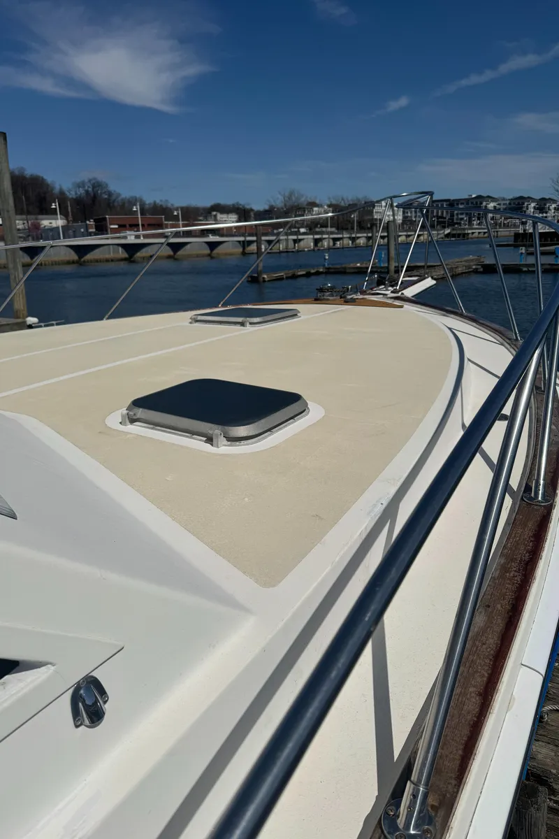 Slide: The Image of 1985 Egg Harbor Convertible yacht docked at a marina under a clear blue sky. - 4