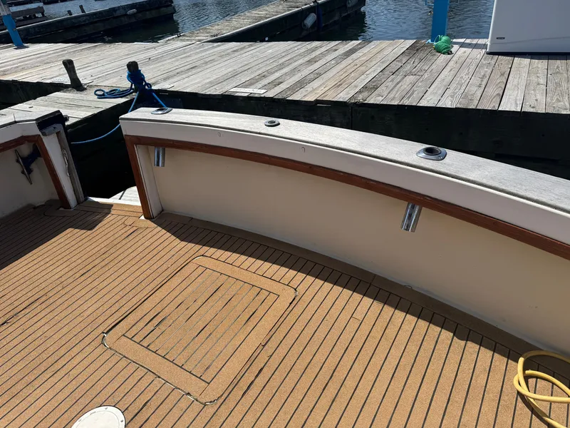 Slide: The Image of 1985 Egg Harbor Convertible boat deck at marina with wooden flooring and dock view. - 5