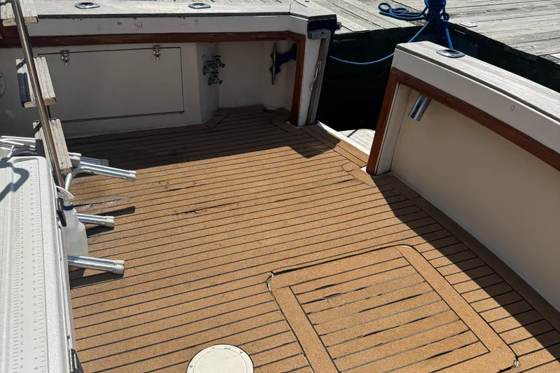 Slide: The Image of 1985 Egg Harbor Convertible boat deck with wood finish and storage compartments. - 6