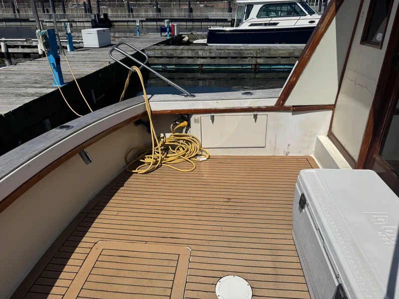 Slide: The Image of 1985 Egg Harbor Convertible boat deck with coiled yellow hose and cooler. - 7