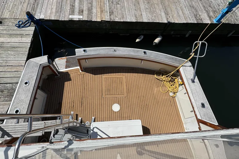 Slide: The Image of 1985 Egg Harbor Convertible boat deck with wooden flooring, docked at a marina. - 8