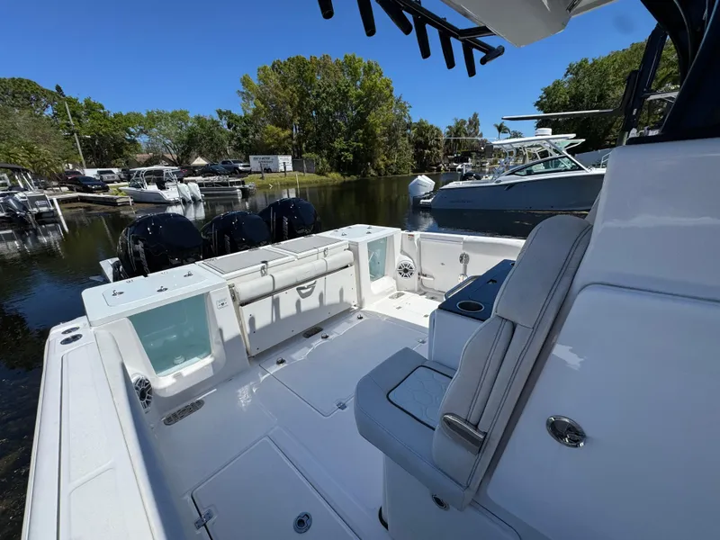 Slide: The Image of 2022 Sea Fox 368 Commander boat interior with seating and outboard motors, docked in a marina. - 21