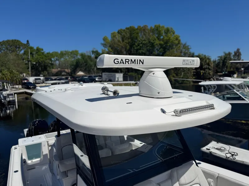 Slide: The Image of 2022 Sea Fox 368 Commander boat with Garmin radar on top, docked near trees. - 30