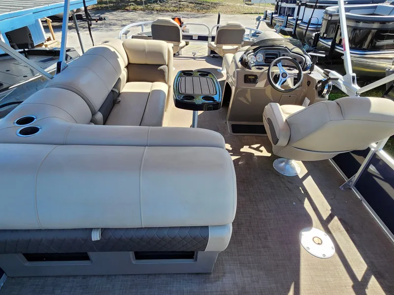 Slide: The Image of 2023 Sun Tracker Fishin' Barge 20 DLX interior with beige seating and steering console. - 11