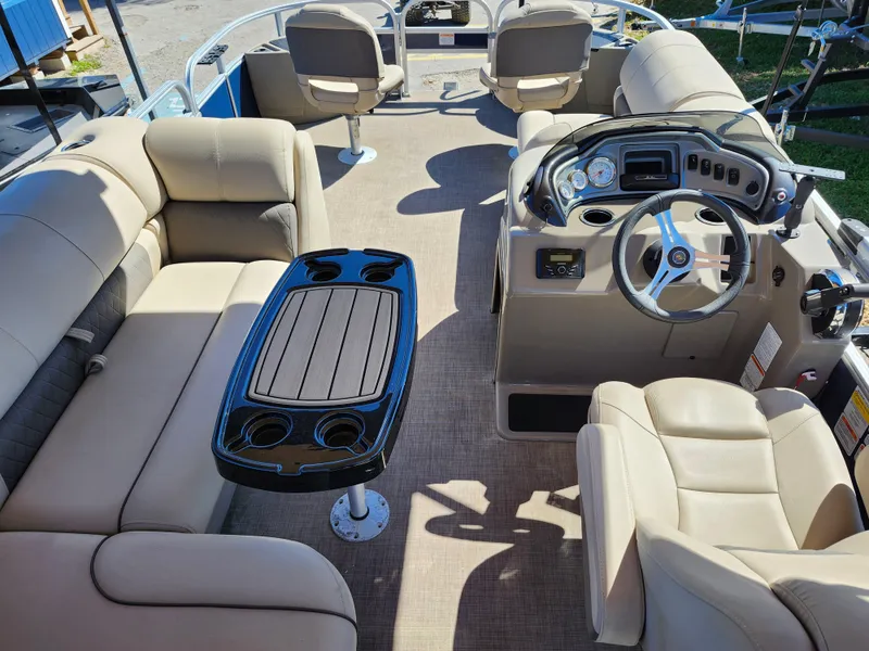 Slide: The Image of 2023 Sun Tracker Fishin' Barge 20 DLX interior with seating, table, and steering console. - 14