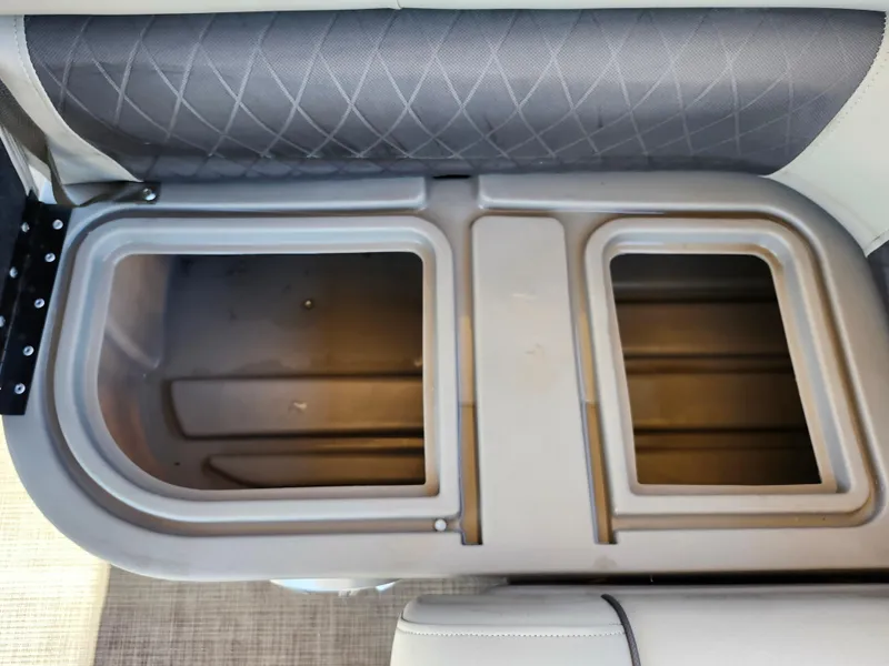 Slide: The Image of 2023 Sun Tracker Fishin' Barge 20 DLX storage compartment with open lid, showcasing interior space. - 19