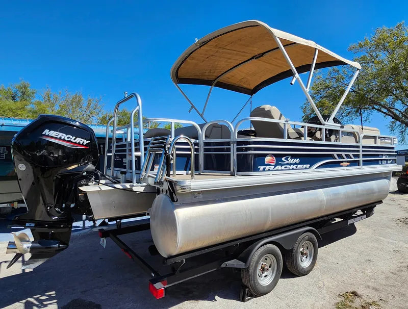 Slide: The Image of 2023 Sun Tracker Fishin' Barge 20 DLX pontoon boat with canopy and Mercury outboard motor. - 6