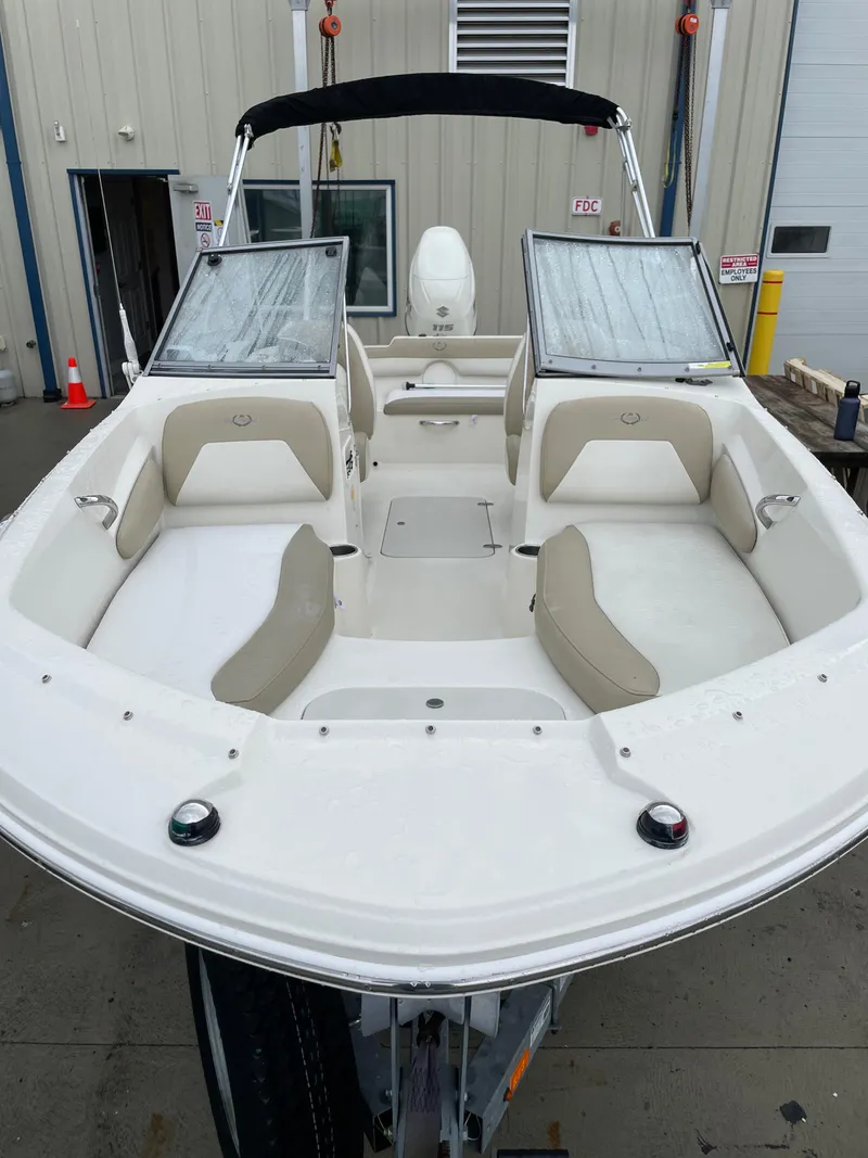 Slide: The Image of 2017 Stingray 191 DC boat with beige seating, docked at a marina. - 3