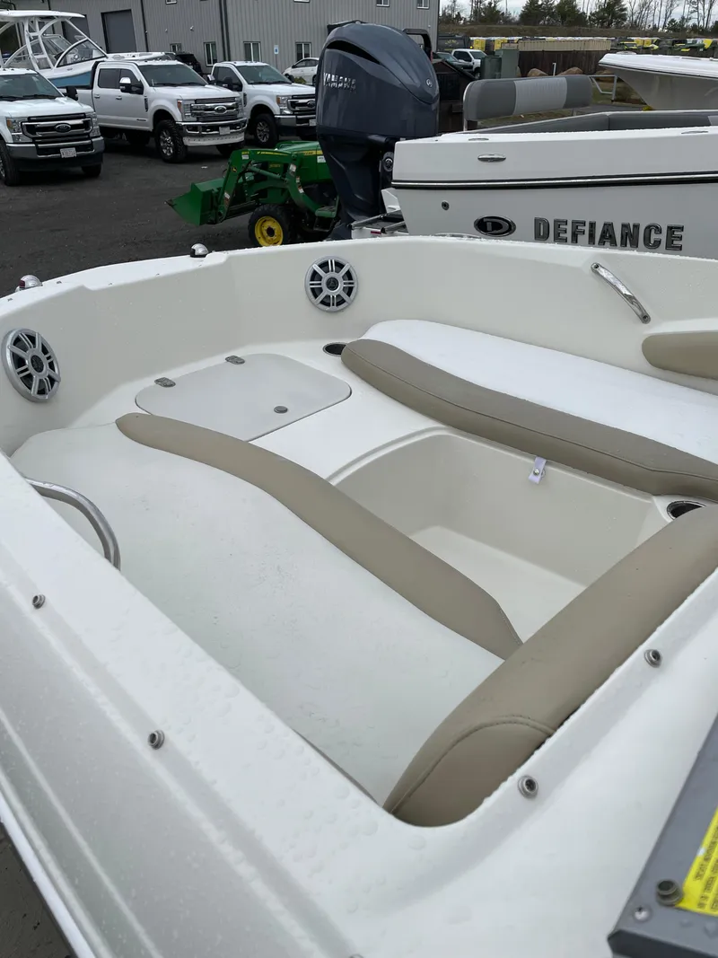 Slide: The Image of 2017 Stingray 191 DC boat interior with beige seating and speakers, parked near other vehicles. - 5