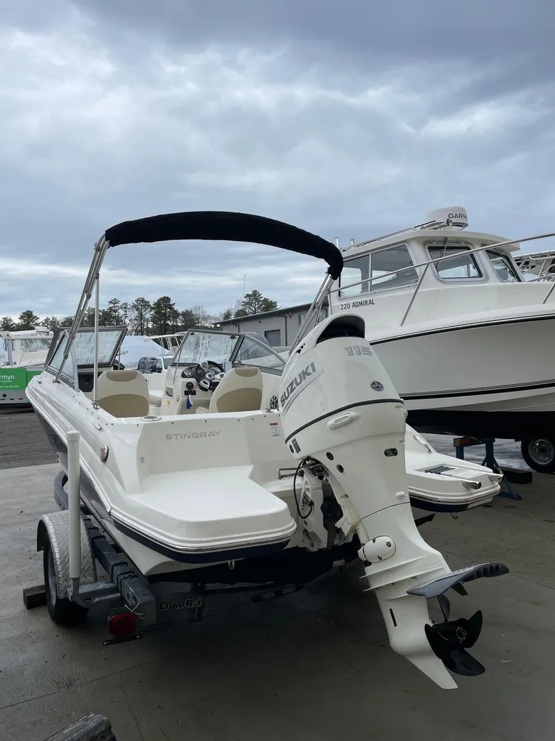 Slide: The Image of 2017 Stingray 191 DC boat with Suzuki outboard motor on trailer, overcast sky. - 6