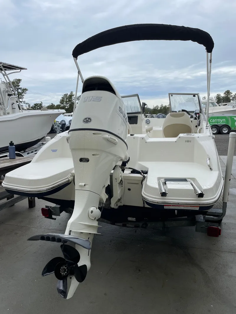 Slide: The Image of 2017 Stingray 191 DC boat with outboard motor and canopy, parked on a trailer. - 7