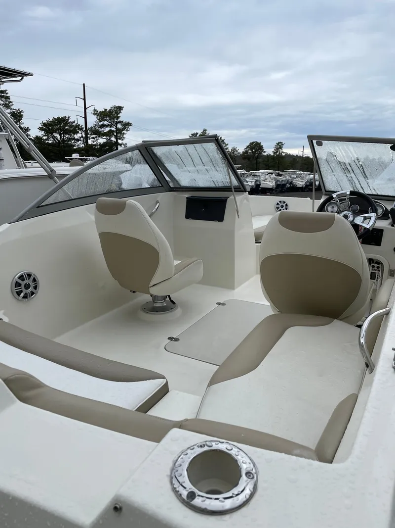 Slide: The Image of 2017 Stingray 191 DC boat interior with beige seating and steering console. - 8