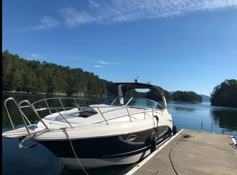 Slide: The Image of 2008 Chaparral 310 Signature boat docked on a serene lake with forested shoreline. - 1