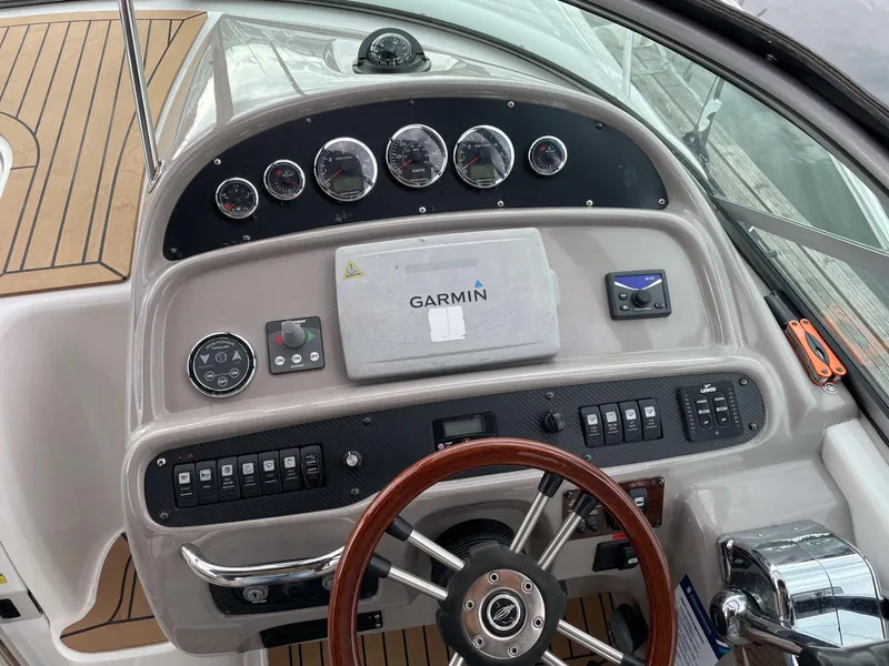 Slide: The Image of 2008 Chaparral 310 Signature boat dashboard with Garmin navigation system and wooden steering wheel. - 10
