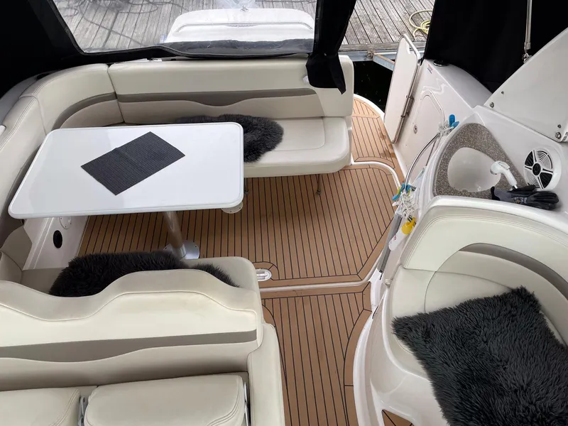 Slide: The Image of 2008 Chaparral 310 Signature boat interior with seating, table, and wood flooring. - 12
