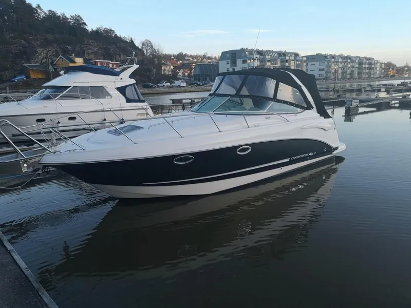 Slide: The Image of 2008 Chaparral 310 Signature boat docked in a marina, calm water, residential backdrop. - 2