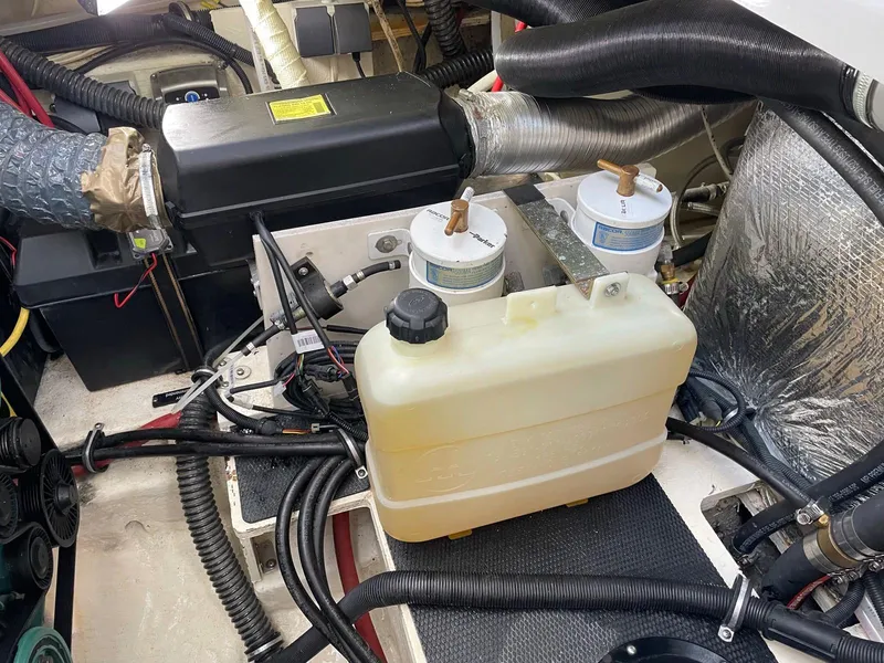 Slide: The Image of Engine compartment of a 2008 Chaparral 310 Signature boat, featuring various components and hoses. - 20