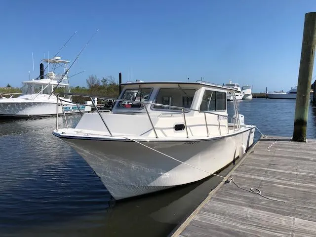 The Image of 2022 May-Craft 2700 Pilot House boat docked at marina under clear blue sky. - 1