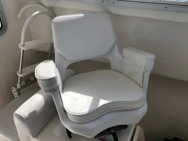 Slide: The Image of White captain's chair in 2022 May-Craft 2700 Pilot House boat interior. - 17
