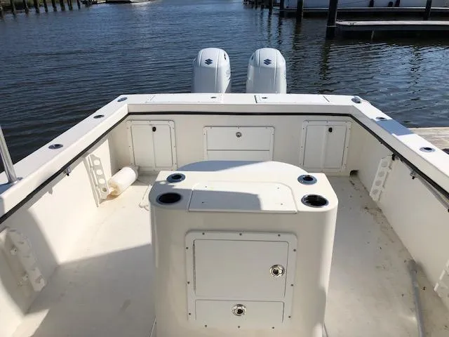 Slide: The Image of 2022 May-Craft 2700 Pilot House boat interior with dual engines, docked by the water. - 23