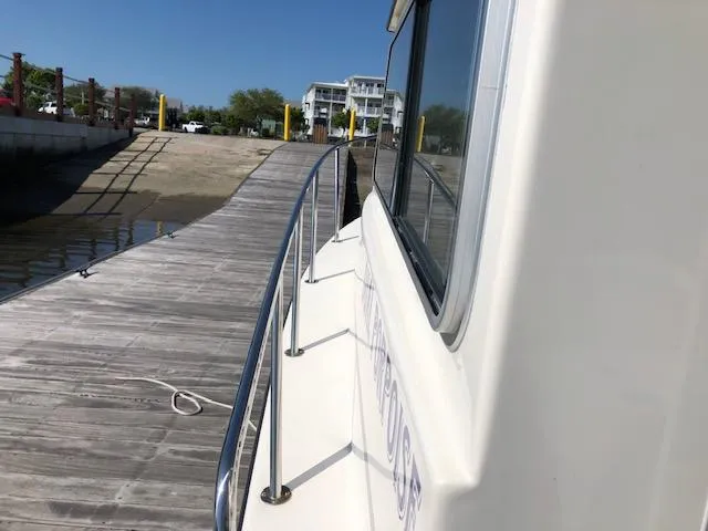Slide: The Image of 2022 May-Craft 2700 Pilot House docked at a wooden pier under clear blue skies. - 25