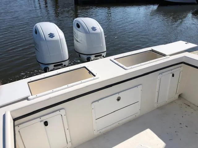 Slide: The Image of 2022 May-Craft 2700 Pilot House boat with twin Suzuki outboard engines on calm water. - 6