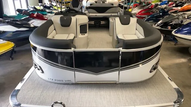 Slide: The Image of 2025 Tahoe LTZ 2385 VRL pontoon boat in showroom, surrounded by jet skis. - 10