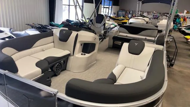 Slide: The Image of 2025 Tahoe LTZ 2385 VRL pontoon boat interior with plush seating in showroom. - 11