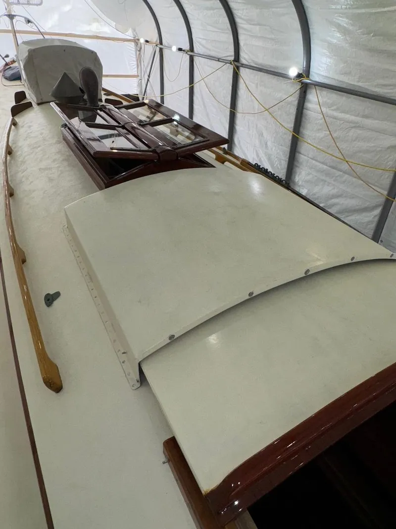 Slide: The Image of 1955 Concordia 39 Yawl deck under cover, showcasing classic design and craftsmanship. - 11