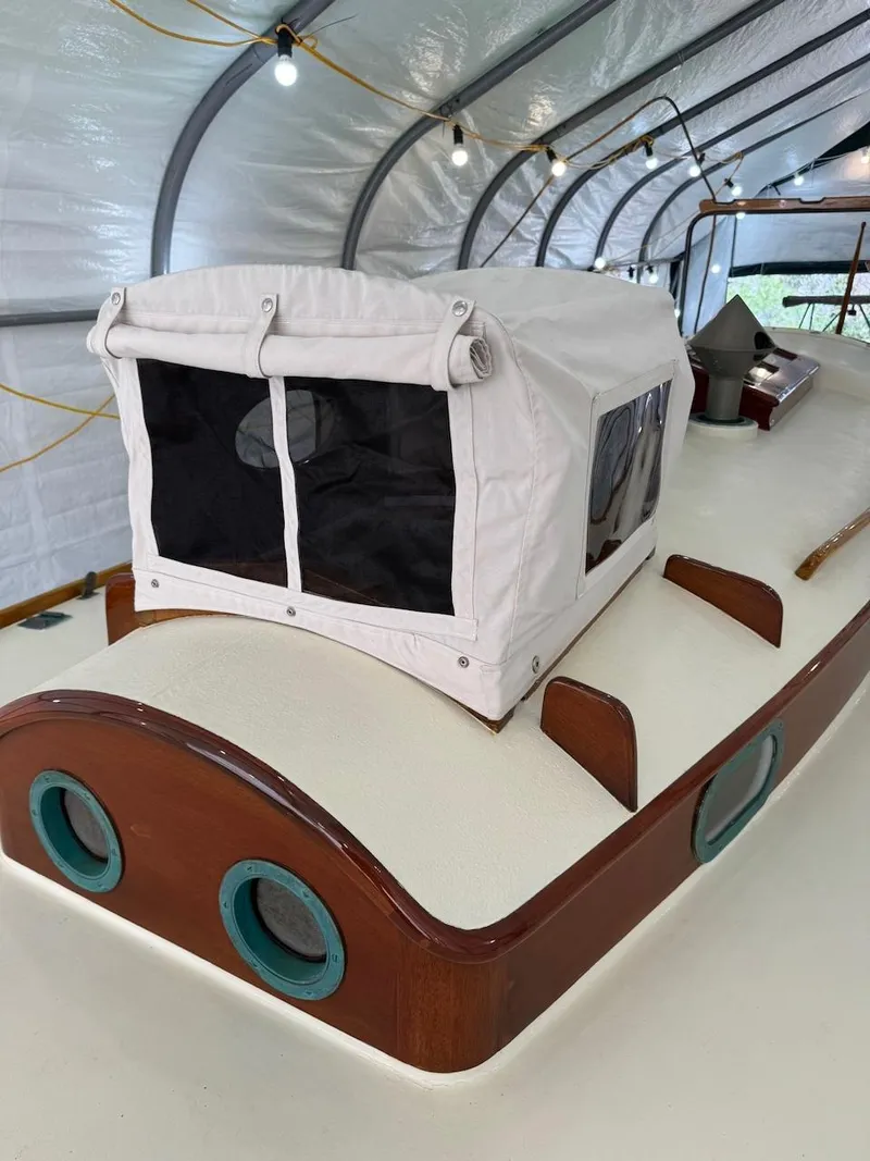 Slide: The Image of 1955 Concordia 39 Yawl with white canopy in a covered storage area. - 13