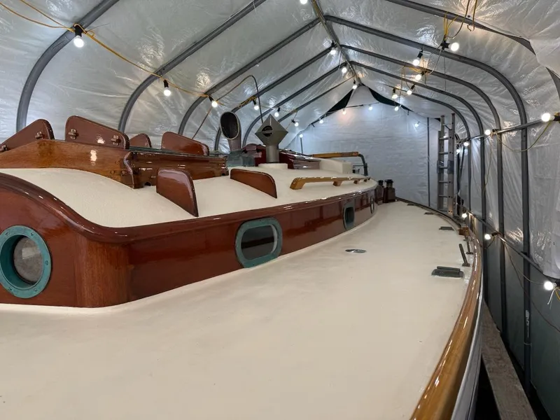 Slide: The Image of 1955 Concordia 39 Yawl in storage, showcasing classic wooden deck and elegant design. - 14