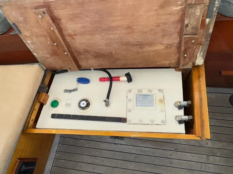 Slide: The Image of Open compartment on 1955 Concordia 39 Yawl, showing various boat components and tools. - 17