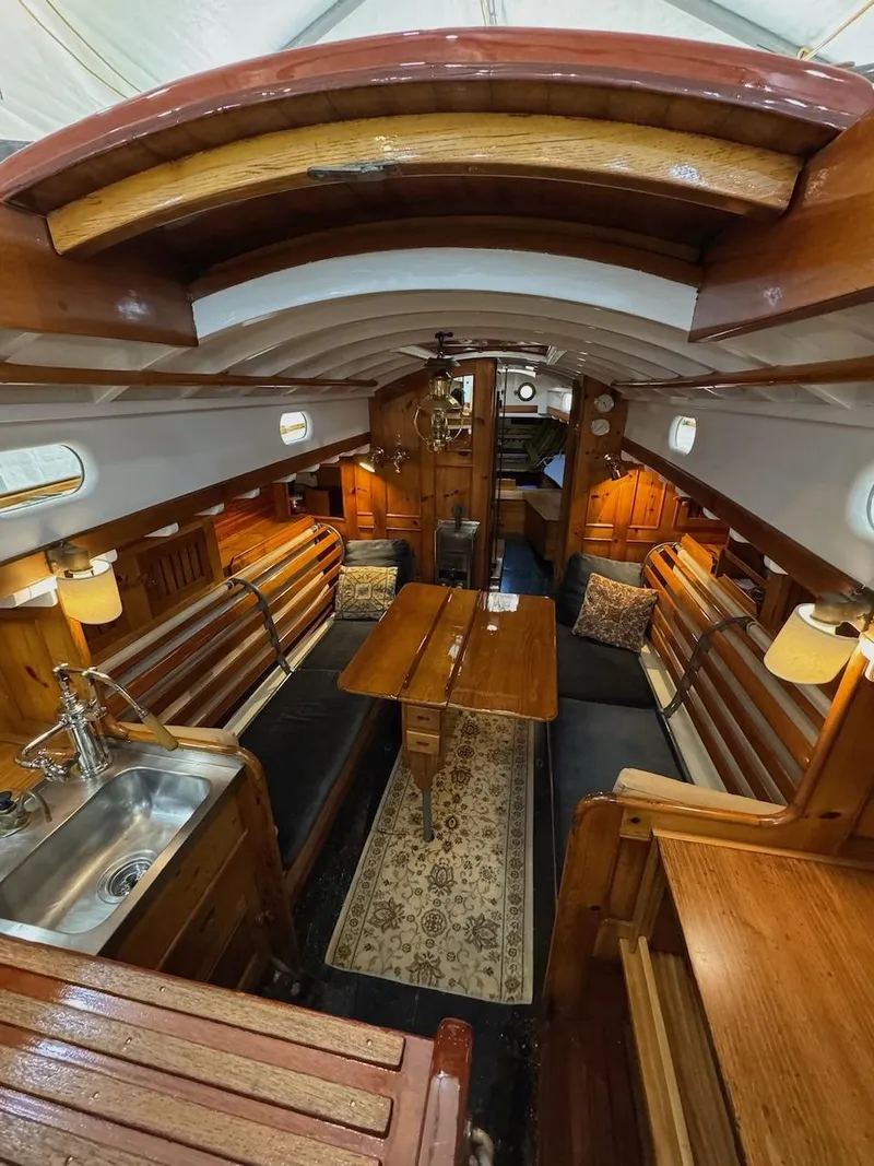 Slide: The Image of Interior of a 1955 Concordia 39 Yawl sailboat with wooden furnishings and cozy seating. - 21