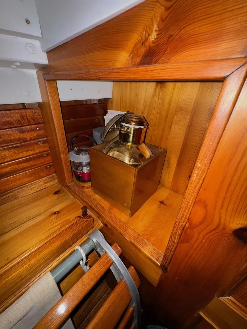 Slide: The Image of Wooden interior of 1955 Concordia 39 Yawl with brass lantern and storage. - 23