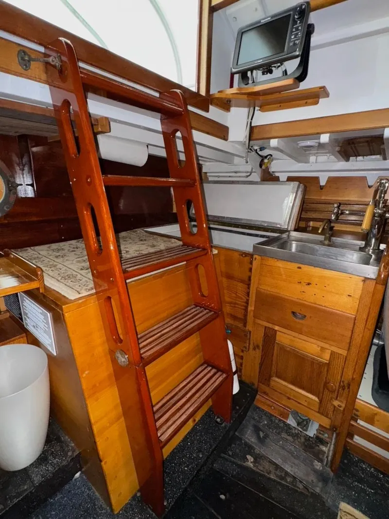 Slide: The Image of Interior of 1955 Concordia 39 Yawl with wooden ladder and compact kitchen area. - 25