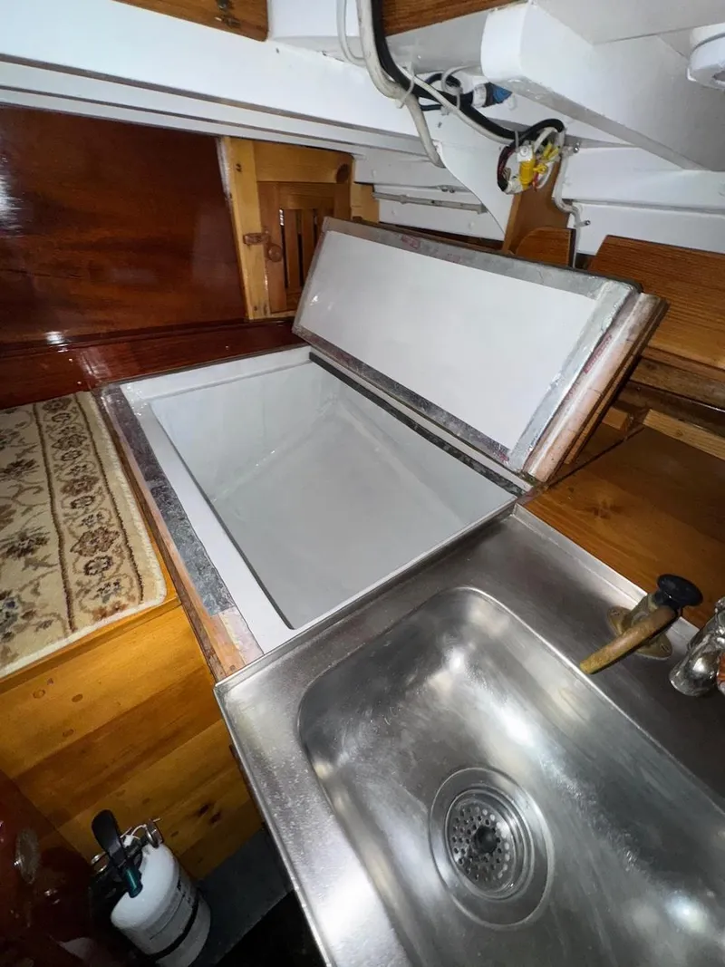 Slide: The Image of Interior of 1955 Concordia 39 Yawl, featuring a stainless steel sink and open storage compartment. - 29