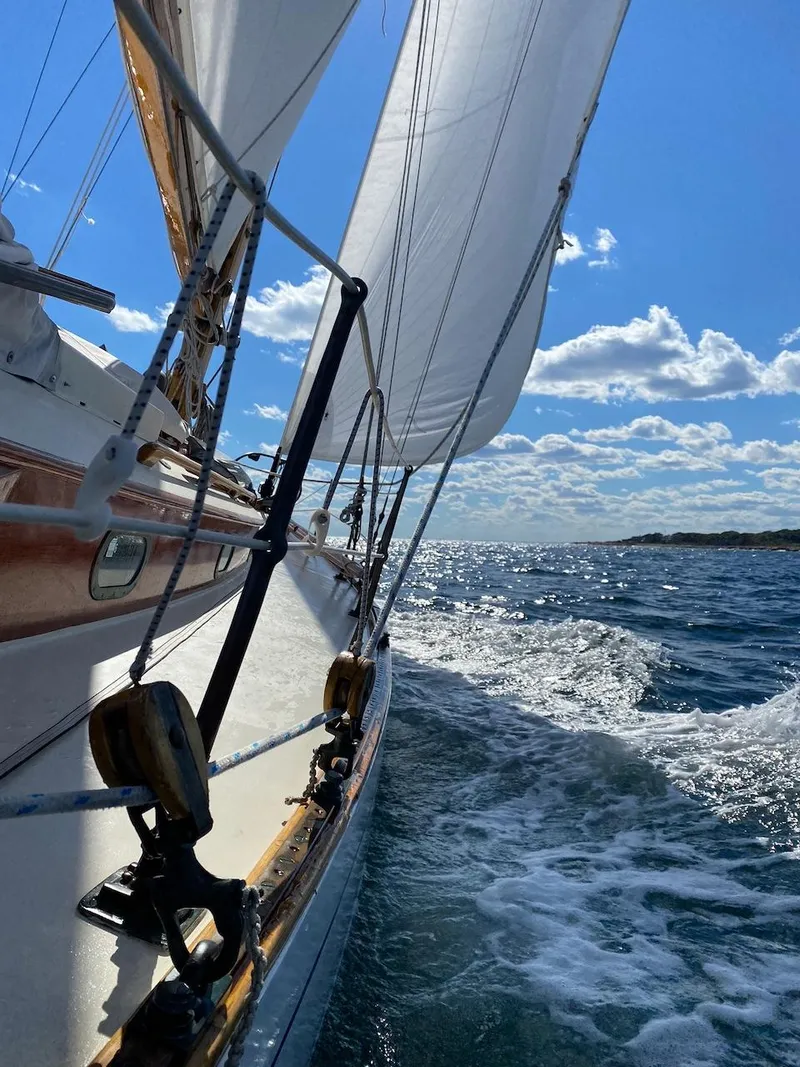 Slide: The Image of 1955 Concordia 39 Yawl sailing on open sea under clear blue sky. - 3
