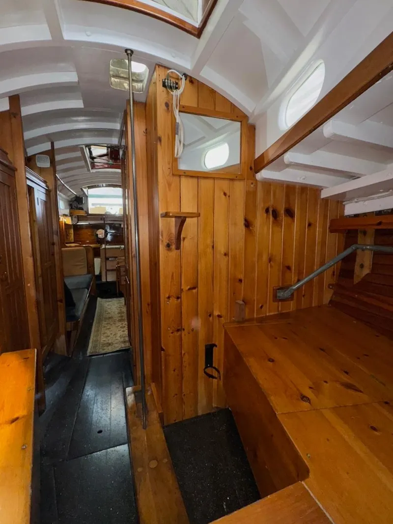 Slide: The Image of Interior of a 1955 Concordia 39 Yawl, featuring wooden paneling and classic nautical design. - 37