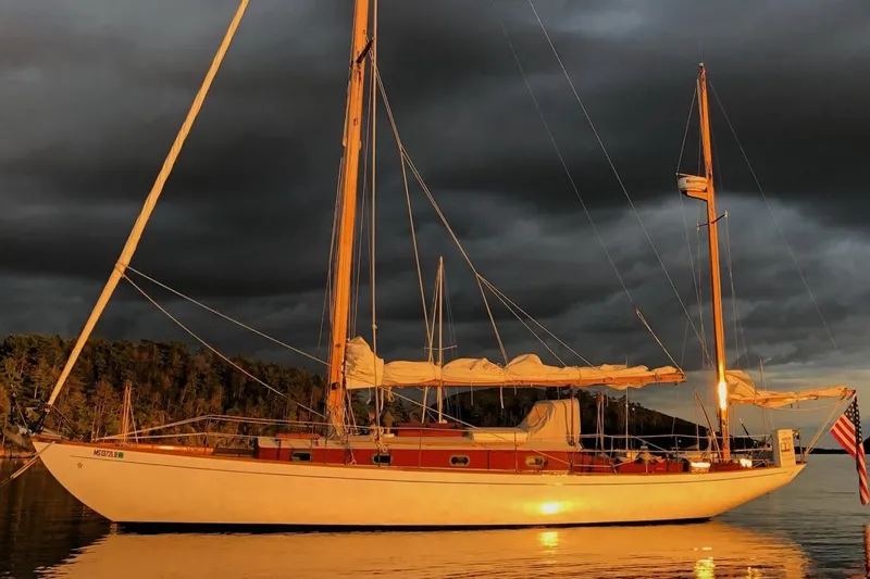 Slide: The Image of 1955 Concordia 39 Yawl sailing at sunset with dramatic sky backdrop. - 4