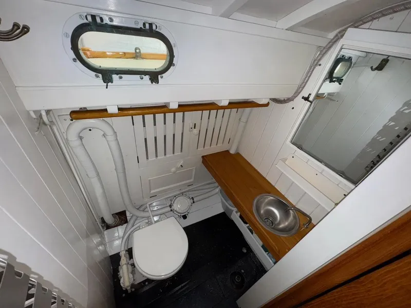 Slide: The Image of Interior of 1955 Concordia 39 Yawl bathroom with porthole, toilet, and sink. - 40