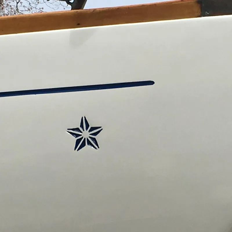 Slide: The Image of 1955 Concordia 39 Yawl hull with blue star emblem and stripe. - 5