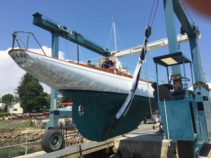 Slide: The Image of Concordia 39 Yawl sailboat from 1955 being lifted by a crane at a marina. - 8