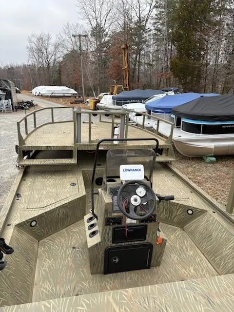 Slide: The Image of 2018 Tracker GRIZZLY 2072 SPORTSMAN boat with Lowrance system, parked near covered boats. - 9