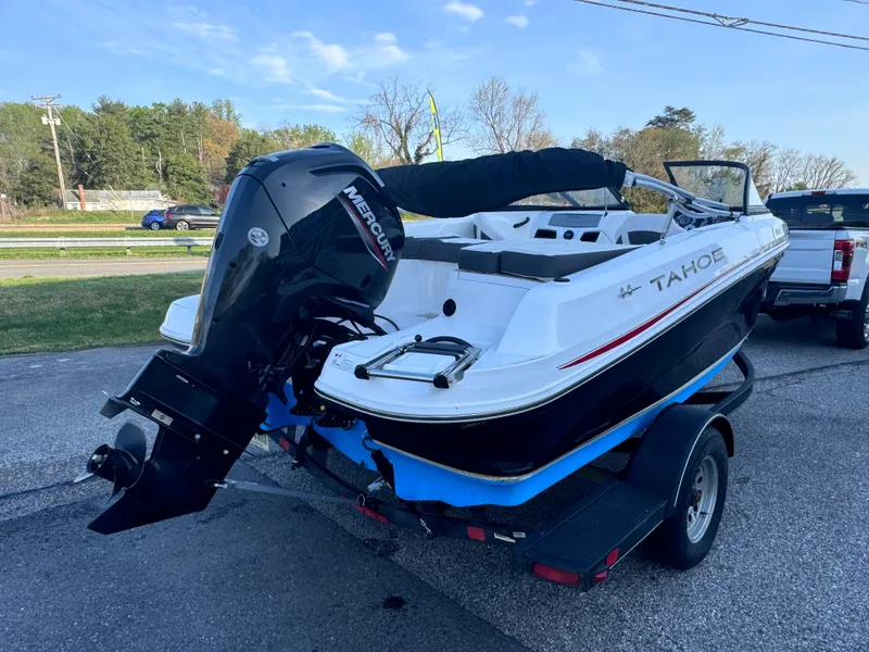 Slide: The Image of 2022 Tahoe 185 S boat on trailer with Mercury outboard motor, parked outdoors. - 2