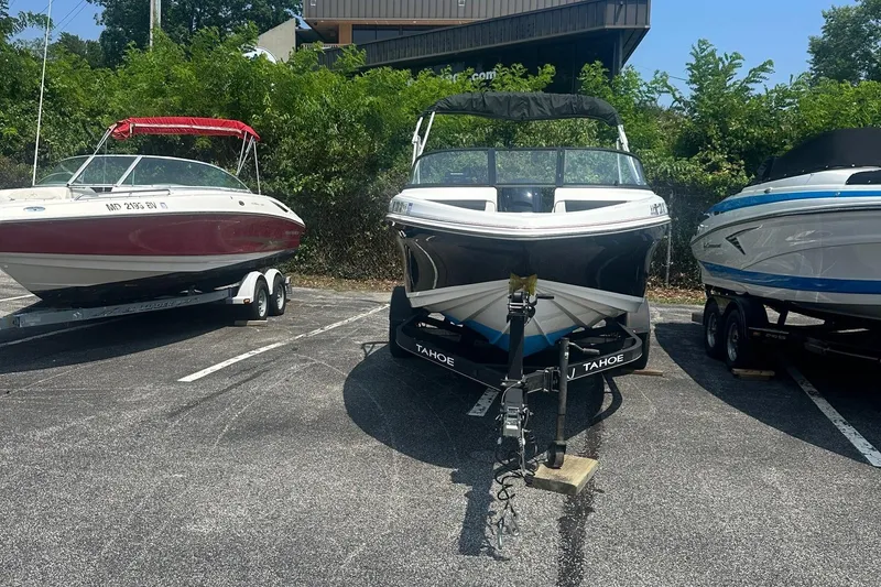 Slide: The Image of 2022 Tahoe 185 S boat on trailer, parked between two other boats. - 5