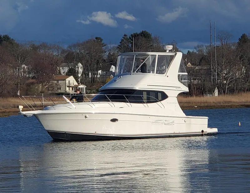 Slide: The Image of 2005 Silverton 34 Convertible yacht on calm water, with scenic background. - 11